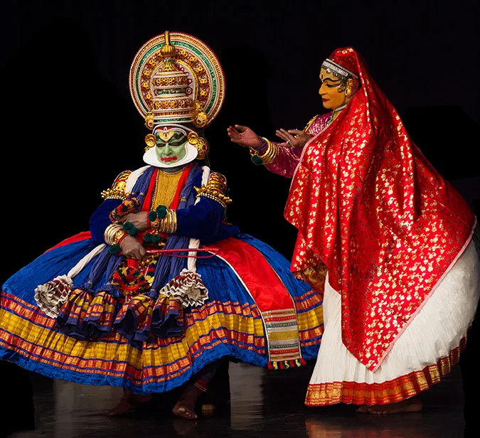 Kathakali-dansere i fargerike kostymer under tradisjonell forestilling i Kerala – en levende del av 